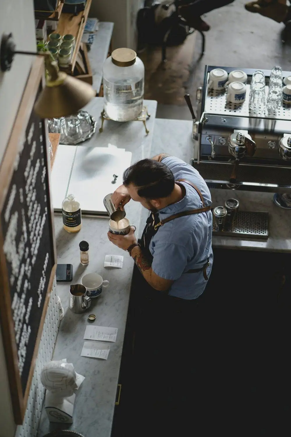 Barista pouring coffee at a cafe counter